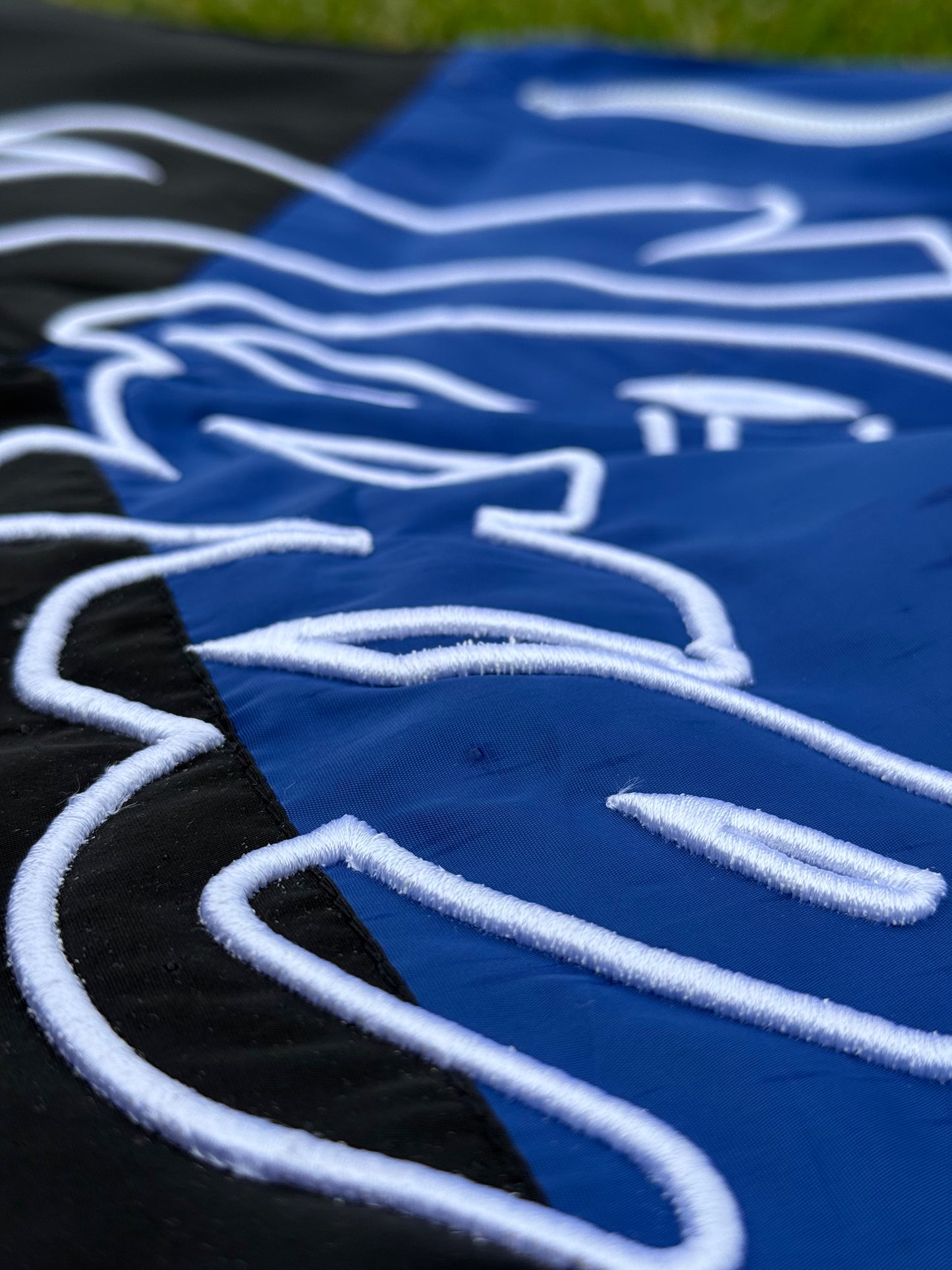 Close-up of blue and black nylon with 3D white embroidery